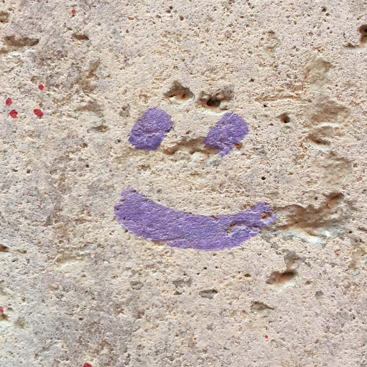 Purple smiley face art on the streets